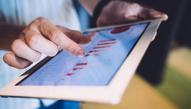 Person reviewing SEO friendly web development data on a tablet