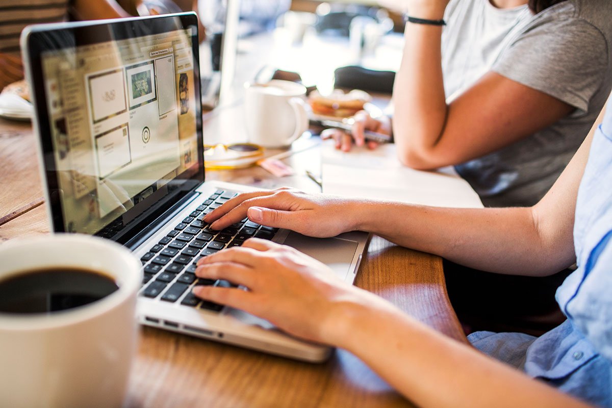 Hands typing on a laptop with WordPress plugin development on screen