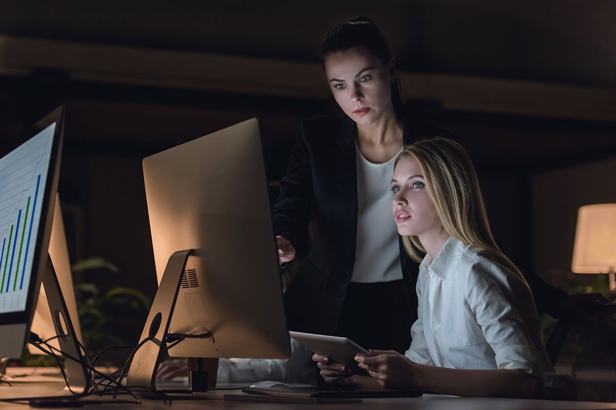Two women collaborating on WordPress website design at a computer